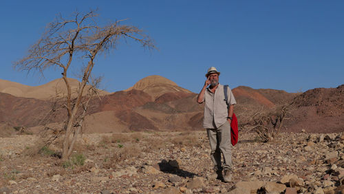 Senior man standing on mountain in the desert 