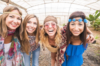 Portrait of smiling friends in greenhouse