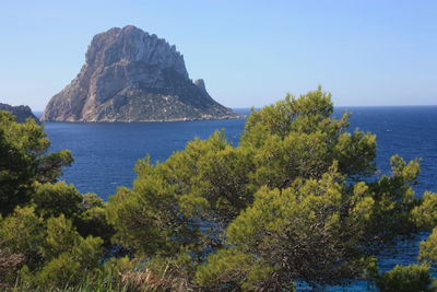The island of es vedra between the blue sky and the blue sea of the ibizan coasts in cala d'hort