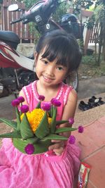 Portrait of cute girl sitting outdoors