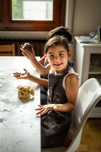 Little girl watching the camera during making a cake