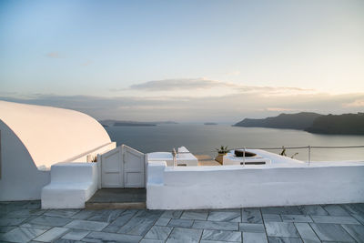 High angle view of houses by sea against sky during sunset