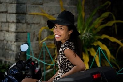 Portrait of smiling young woman sitting on motor scooter 