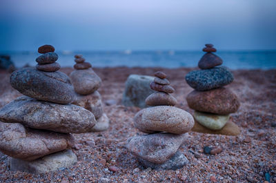 Stack of pebbles on beach against sky