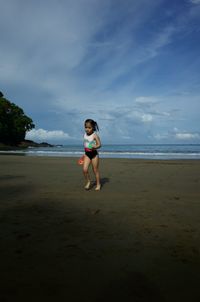 Full length of boy on beach against sky