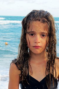 Portrait of sad girl with messy wet hair at beach