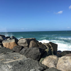 Rocks on beach against sky