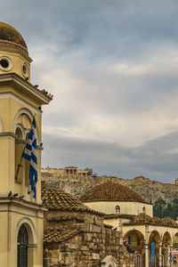 Buildings in city against cloudy sky