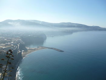 Scenic view of sea and mountains against sky