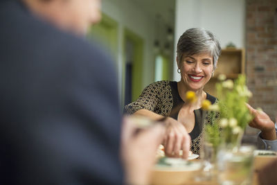 Smiling woman at table during social gathering