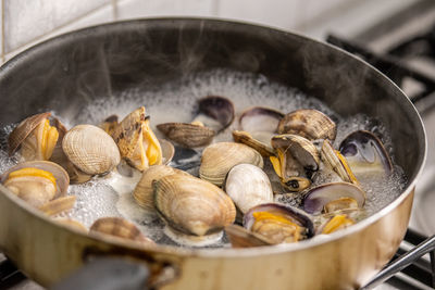 Cooking clams in boiling water in a pan on the stove, preparing spaghetti or linguine with clams