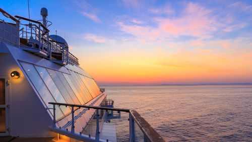 Ship sailing on sea against sky during sunset