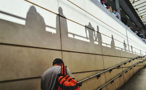 Rear view of man standing on railing