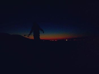 Silhouette of trees against sky at night