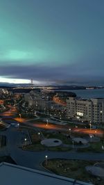 High angle view of illuminated city buildings against sky at dusk