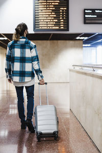 Man walking with luggage at subway station during covid-19