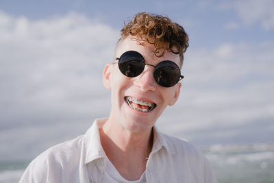 Portrait of smiling young man against sky