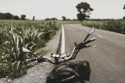 Motorcycle on roadside by field