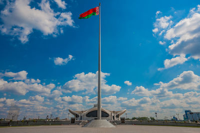 Low angle view of flags against blue sky