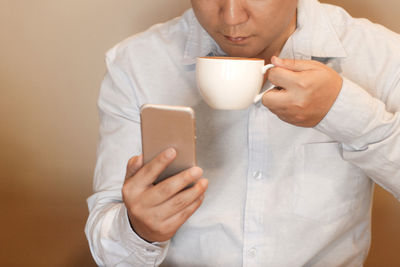 Midsection of man using mobile phone