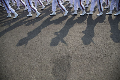 Low section of people walking on road during parade