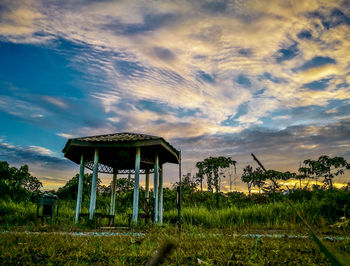 Built structure on landscape against dramatic sky