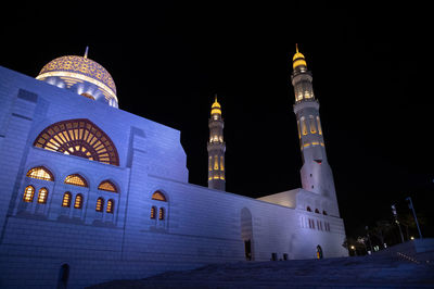 Low angle view of illuminated building against sky at night