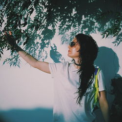 Woman standing against tree