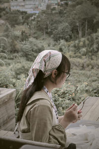 Side view of woman sitting on field