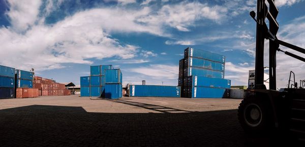 Cars on pier at beach against sky