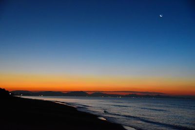 Scenic view of sea against clear sky at sunset