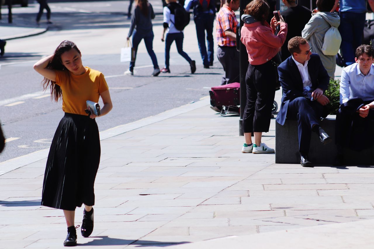 REAR VIEW OF PEOPLE WALKING ON STREET