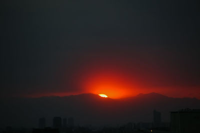 Scenic view of silhouette mountains against romantic sky at sunset