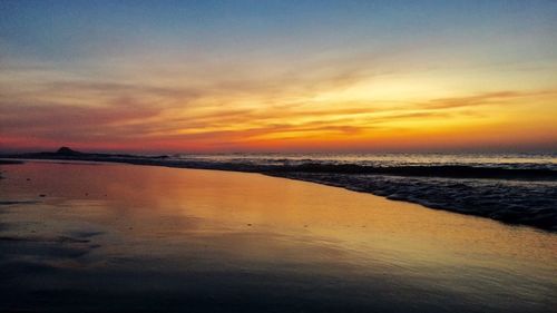 Scenic view of beach against sky during sunset