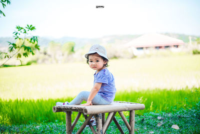 Portrait of boy sitting on land