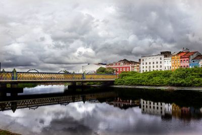 River in town against cloudy sky