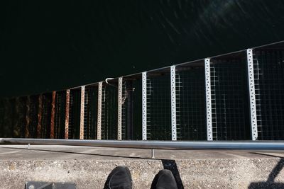 Low section of man standing by water