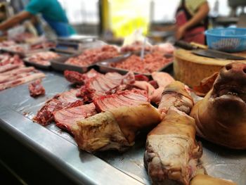 Close-up of butchers cutting meat in shop