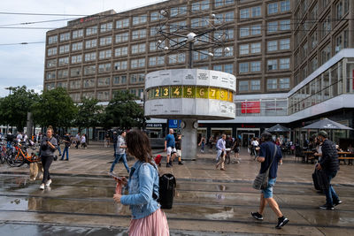 People walking on road amidst buildings in city