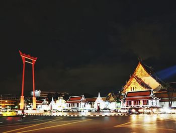 Illuminated buildings against sky at night
