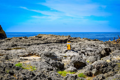 Scenic view of rocks on beach against sky