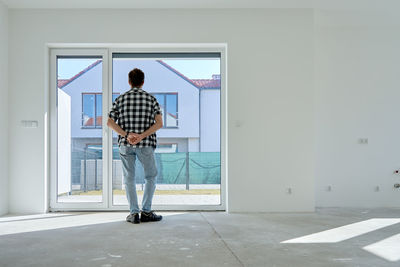 Full length rear view of woman standing against building
