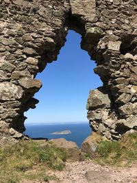 Rock formations by sea against sky