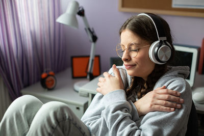 A girl delighted with new songs. listens to music on wireless headphones.