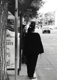 Rear view of man walking on street in city