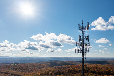 Communications tower against sky on sunny day