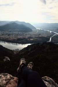 Low section of man on mountains against sky