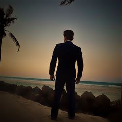 Rear view of man looking at sea against sky