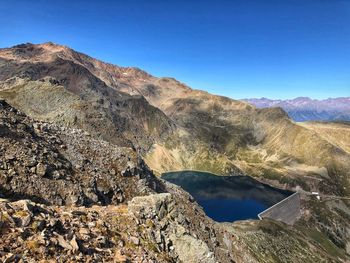 Scenic view of lake by mountains against clear sky