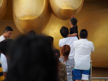 Rear view of people standing in temple